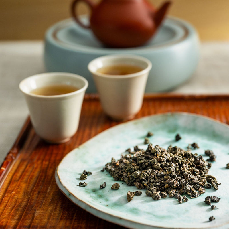 A plate with a cup of Iron Goddess of Mercy tea and a bowl of goji berries from Rishi Tea & Botanicals.